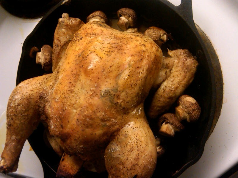Roast chicken in a cast iron skillet just out of the oven.
