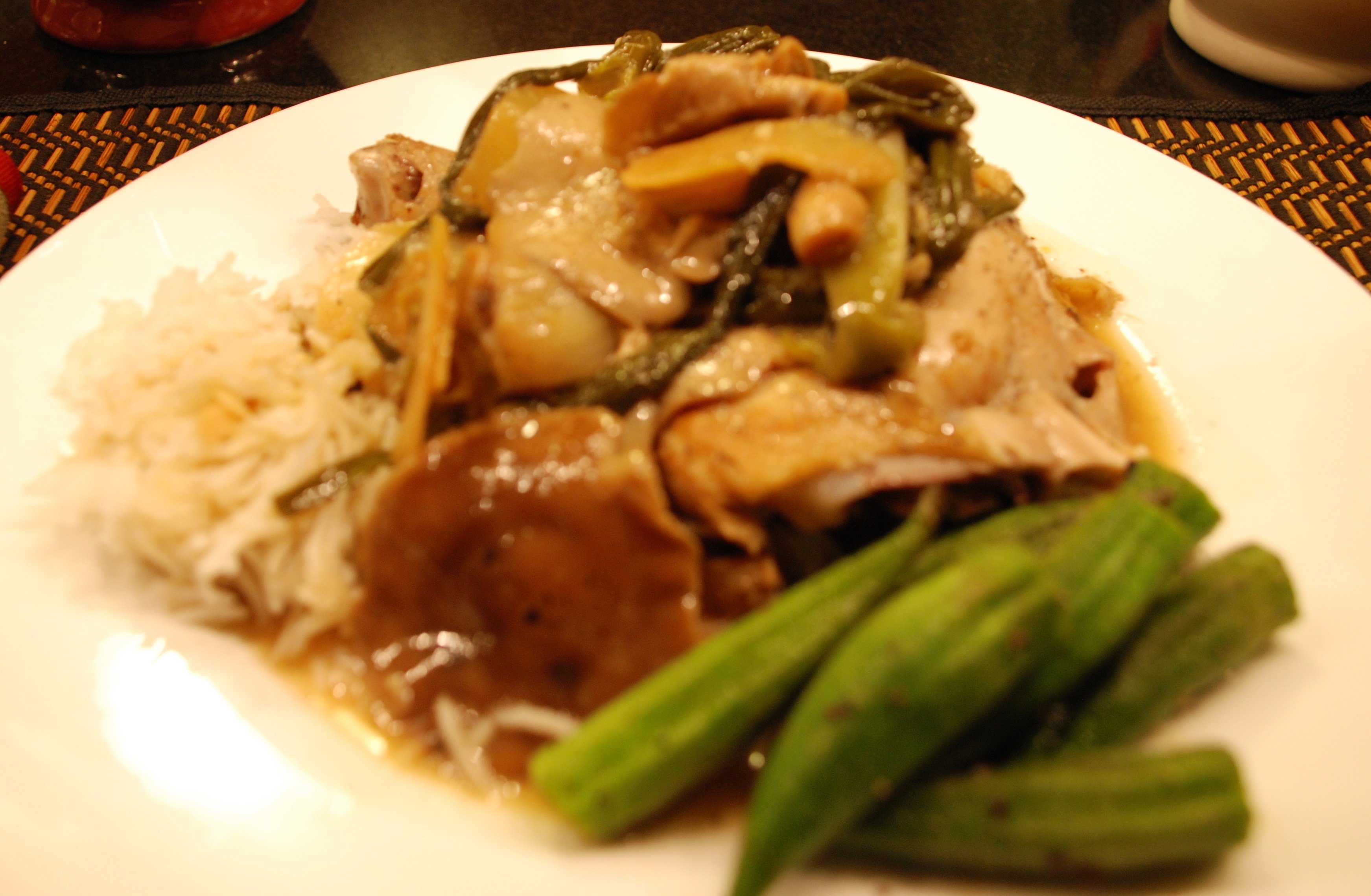 Sesame braised chicken with shiitake mushrooms and daikon on a white plate.