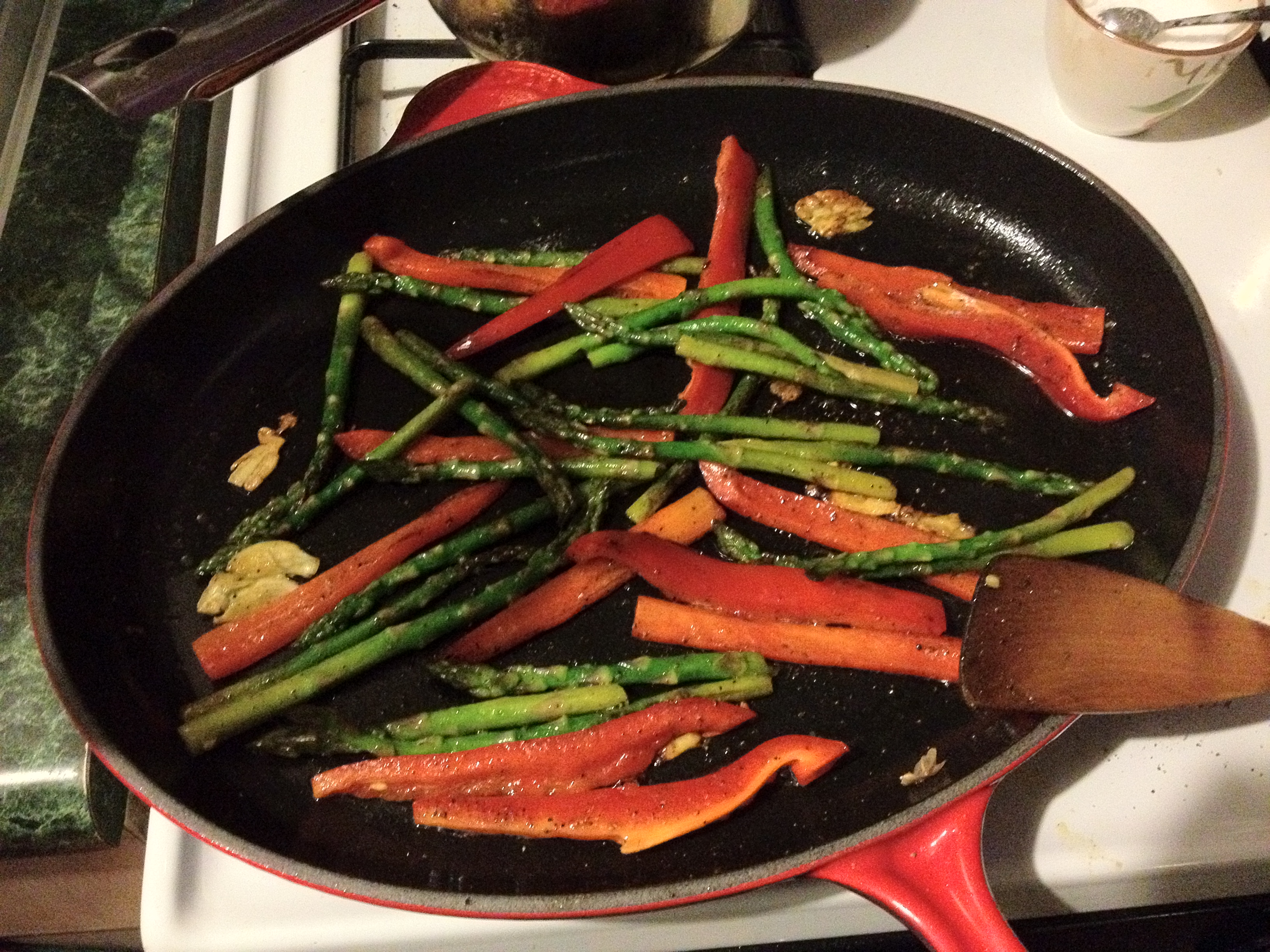 Asparagus and red peppers in a skillet.