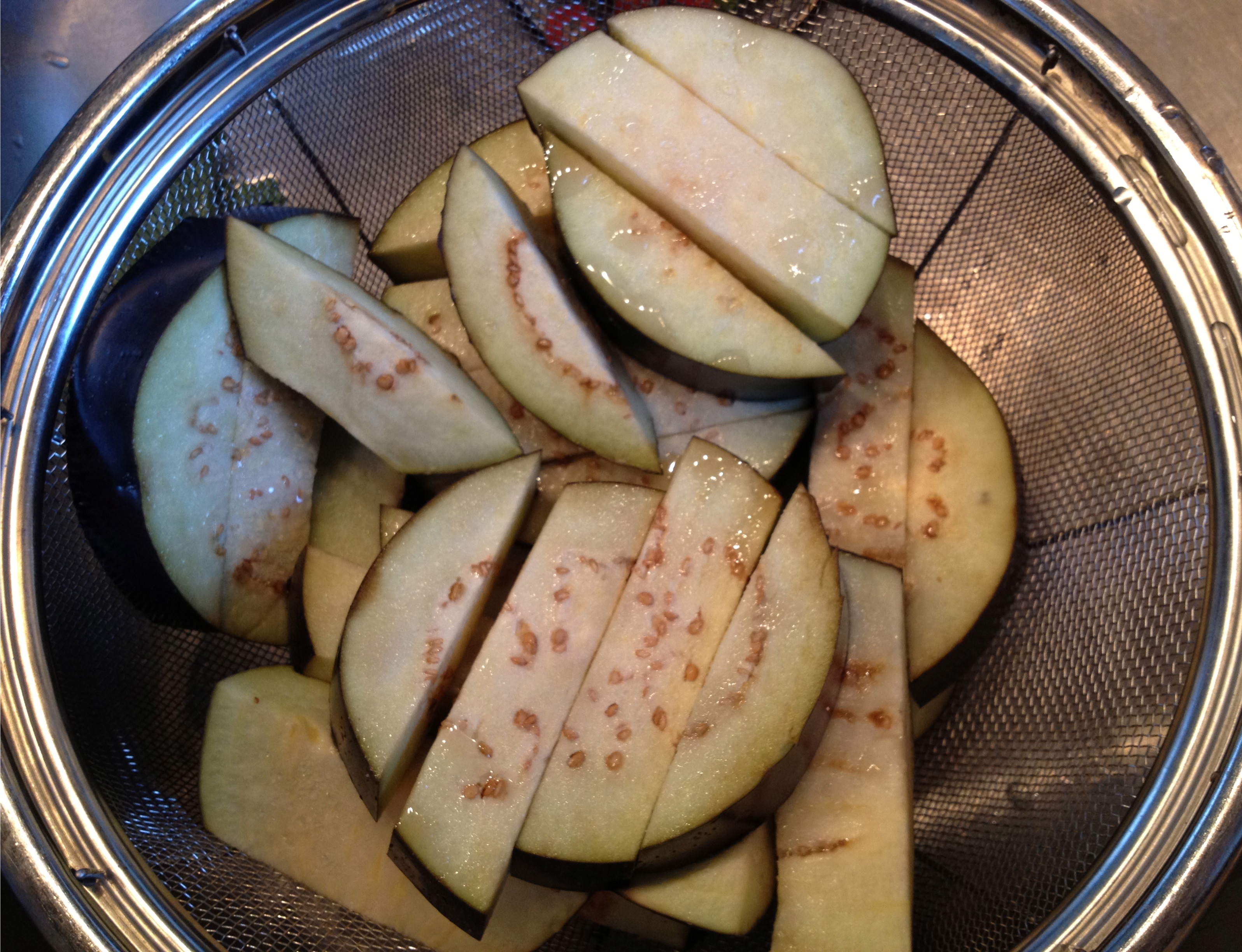 Salted eggplant in a colander.