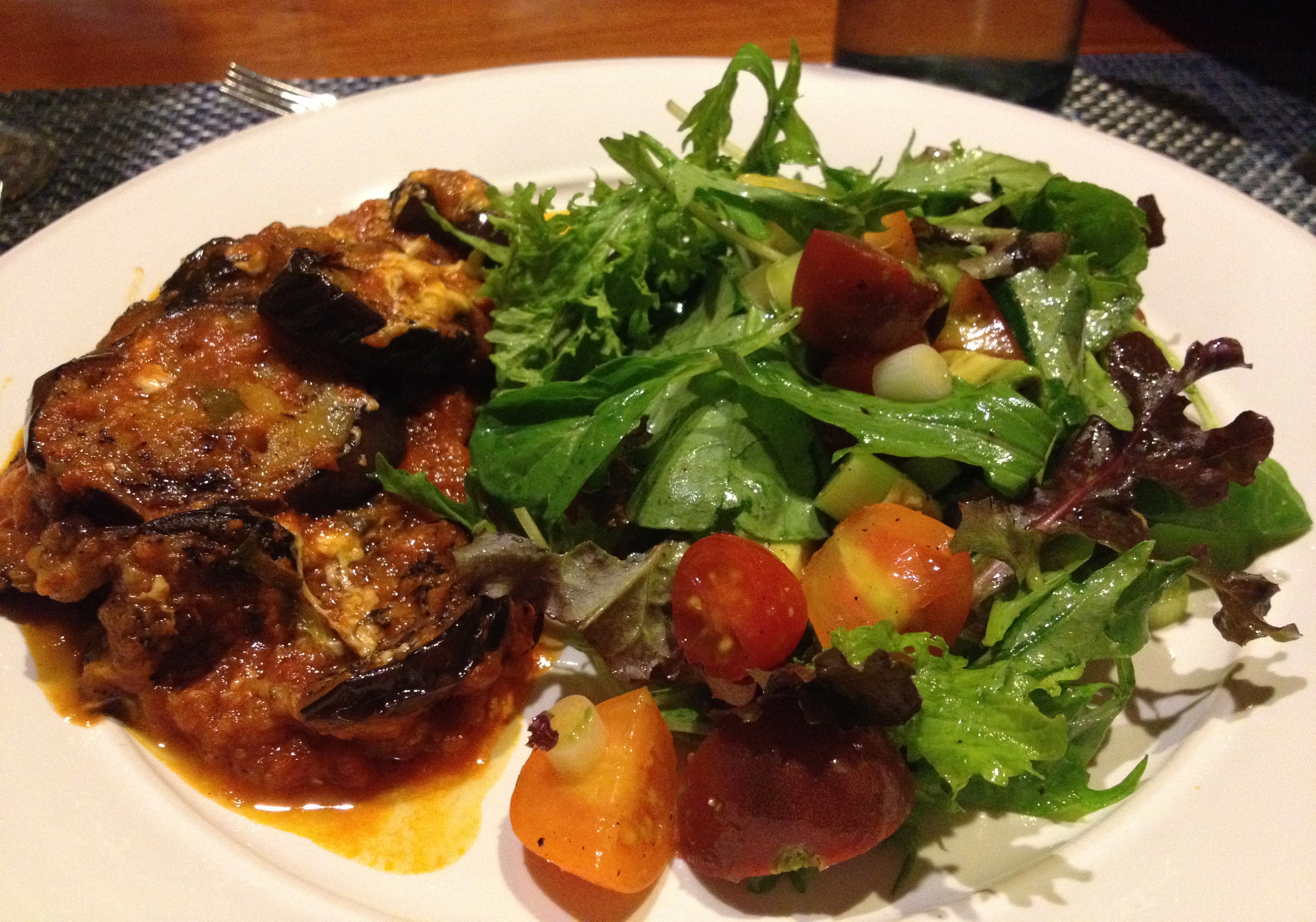Eggplant Parmigiano and farm stand salad on a white plate.