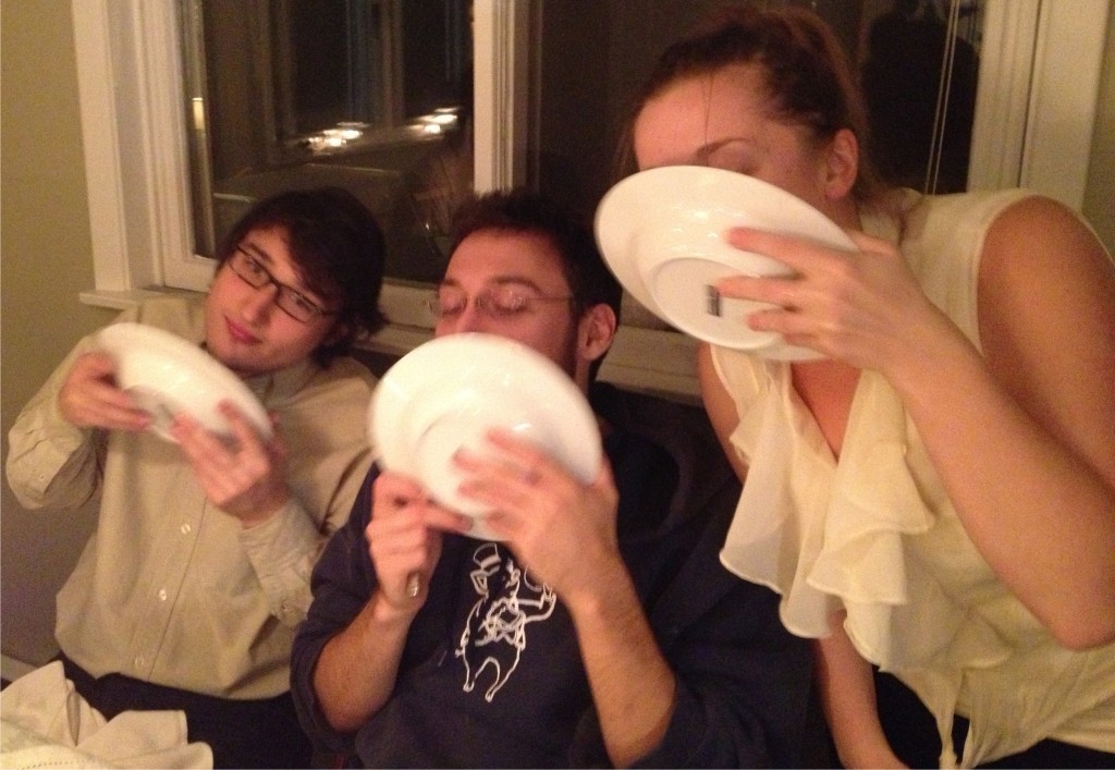 Three kids licking their soup bowls clean