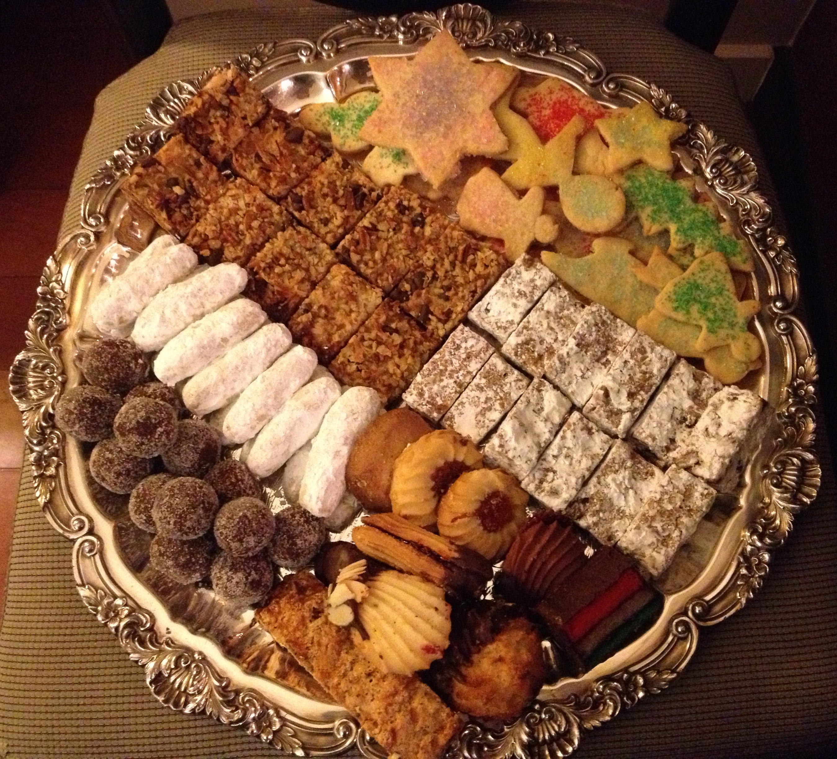 Christmas/holiday cookie platter with Cognac sugarplums, hello Dolly Squares, date bars, sugar cookies, pecan crisps, and special bakery cookies