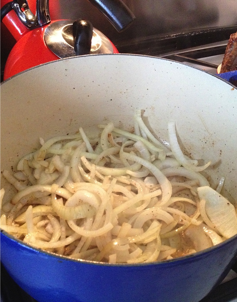 Onions sauteing in a Le Creuset pot.