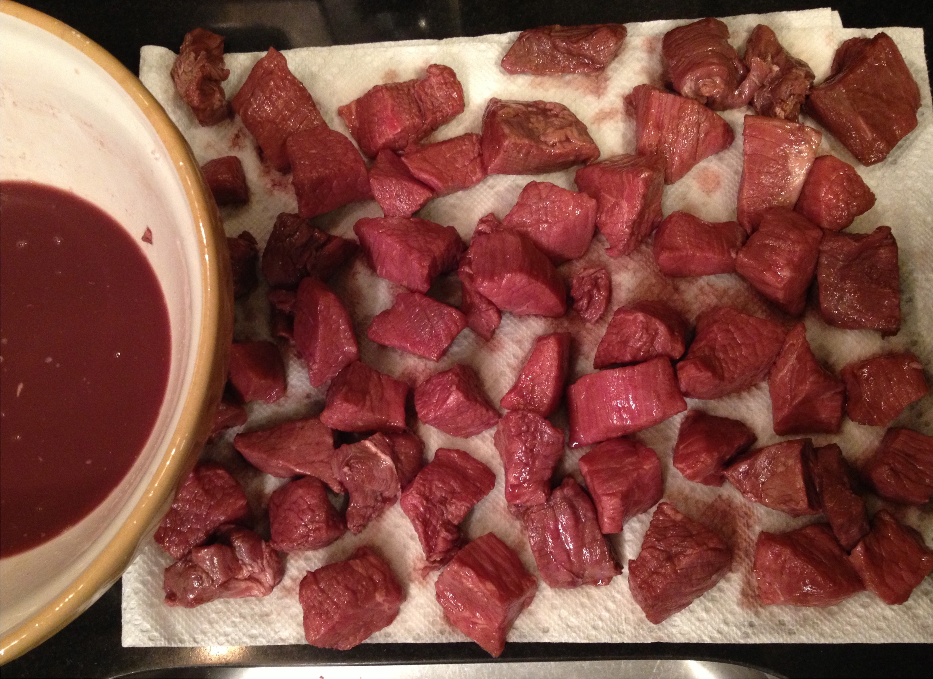 Beef stew - marinated cubes of beef drying on paper towels.
