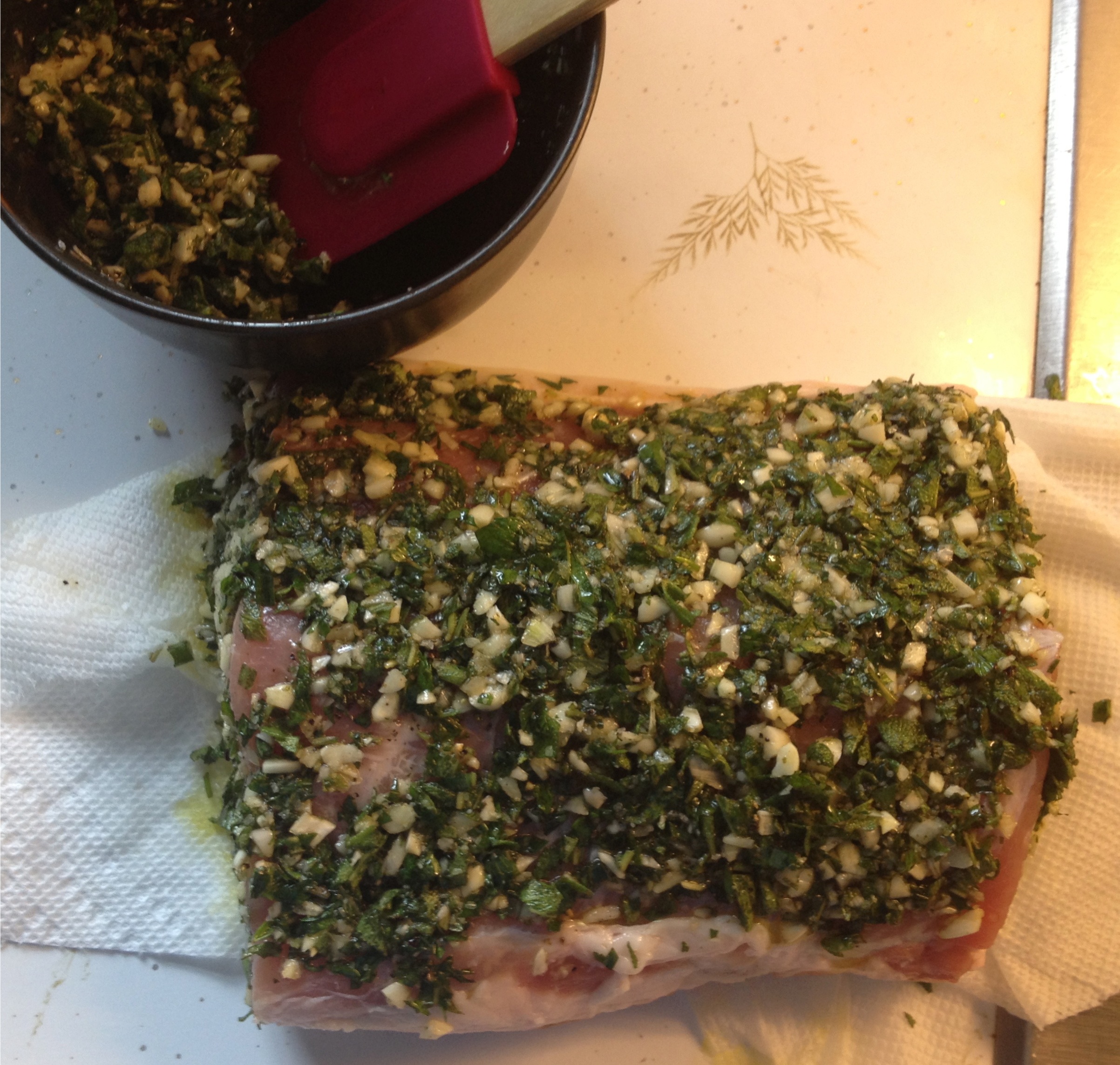 Herb, garlic and olive oil marinade on a pork loin roast.