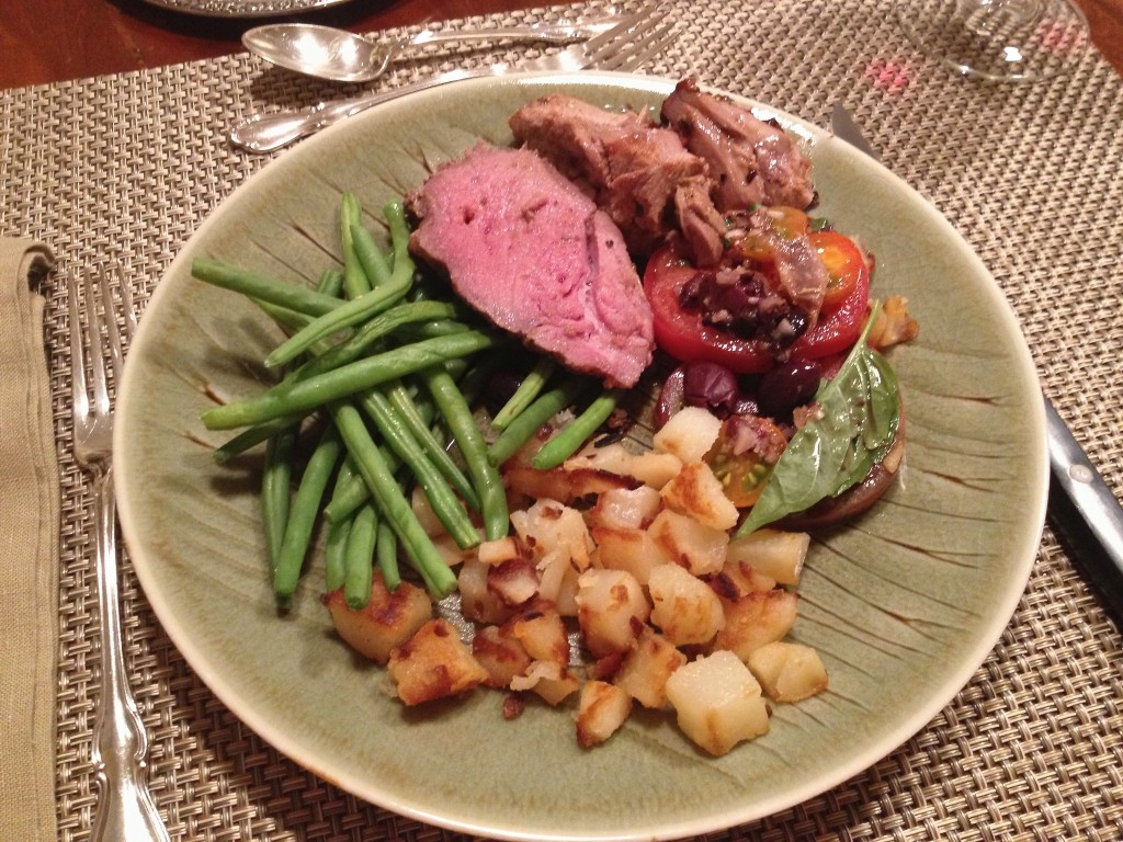 Dinner plate with Leg of Lamb, Nicoise tomatoes, haricot vert, and roasted potatoes.