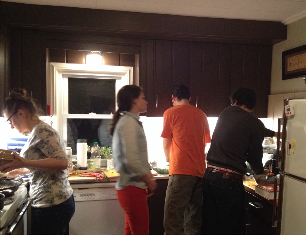 Four young adults cooking in a kitchen