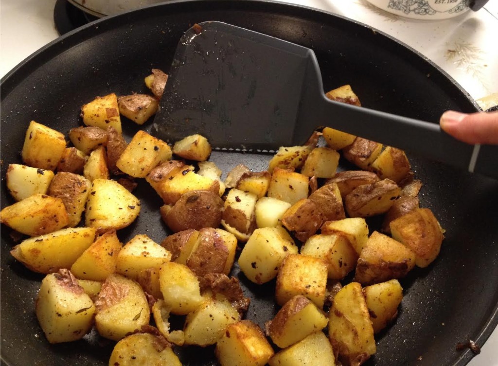 Calphalon serrated spatula cutting a potato.