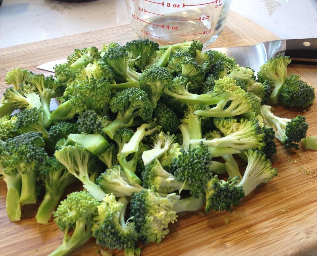 Broccoli flowerets on a cutting board.