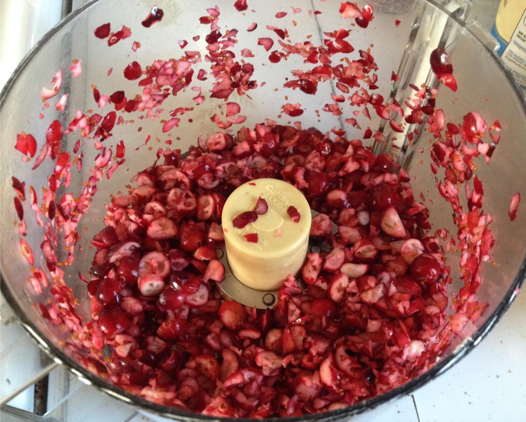 Chopped fresh cranberries in a food processor bowl.