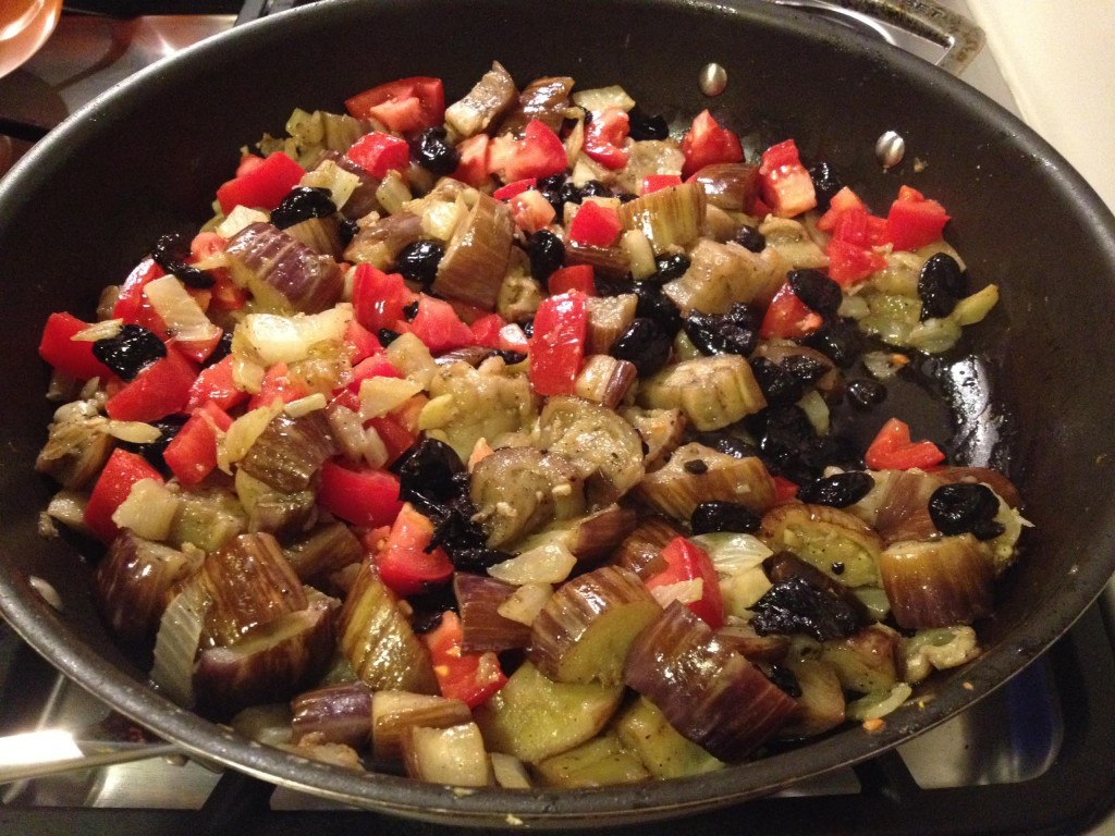 Eggplant, mozzarella and oil cured black olives in a skillet.