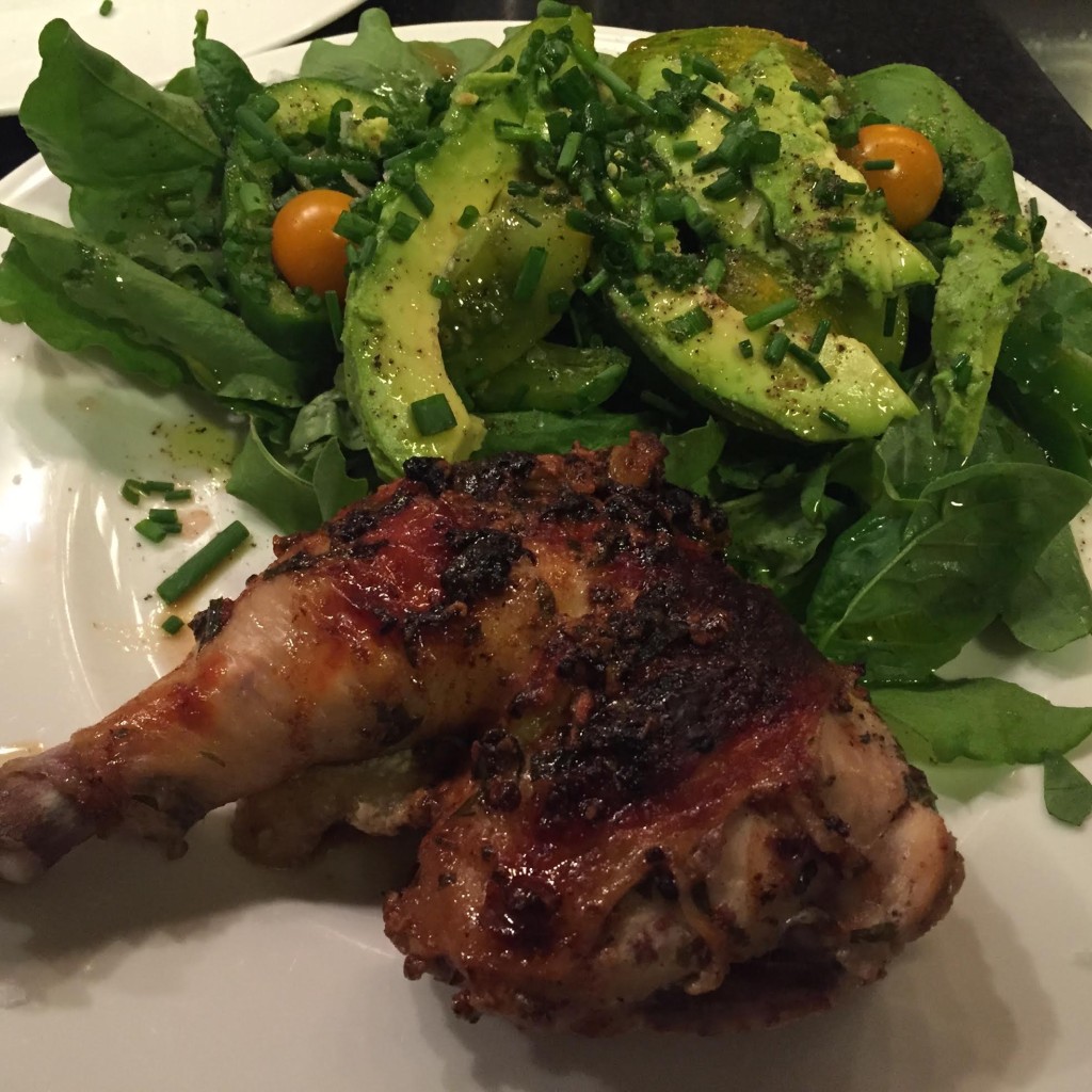 Buttermilk marinated roast chicken with tarragon and Dijon mustard on a plate with sorrel avocado tomato and chive salad.