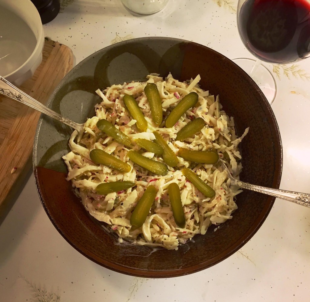 Sauerkraut salad with string cheese in a brown pottery bowl.
