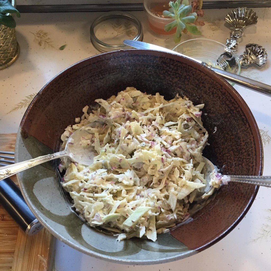 Sauerkraut salad with string cheese in a bowl before garnishes.