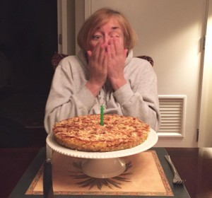 Mary finished blowing out the candle on a pear almond tart.