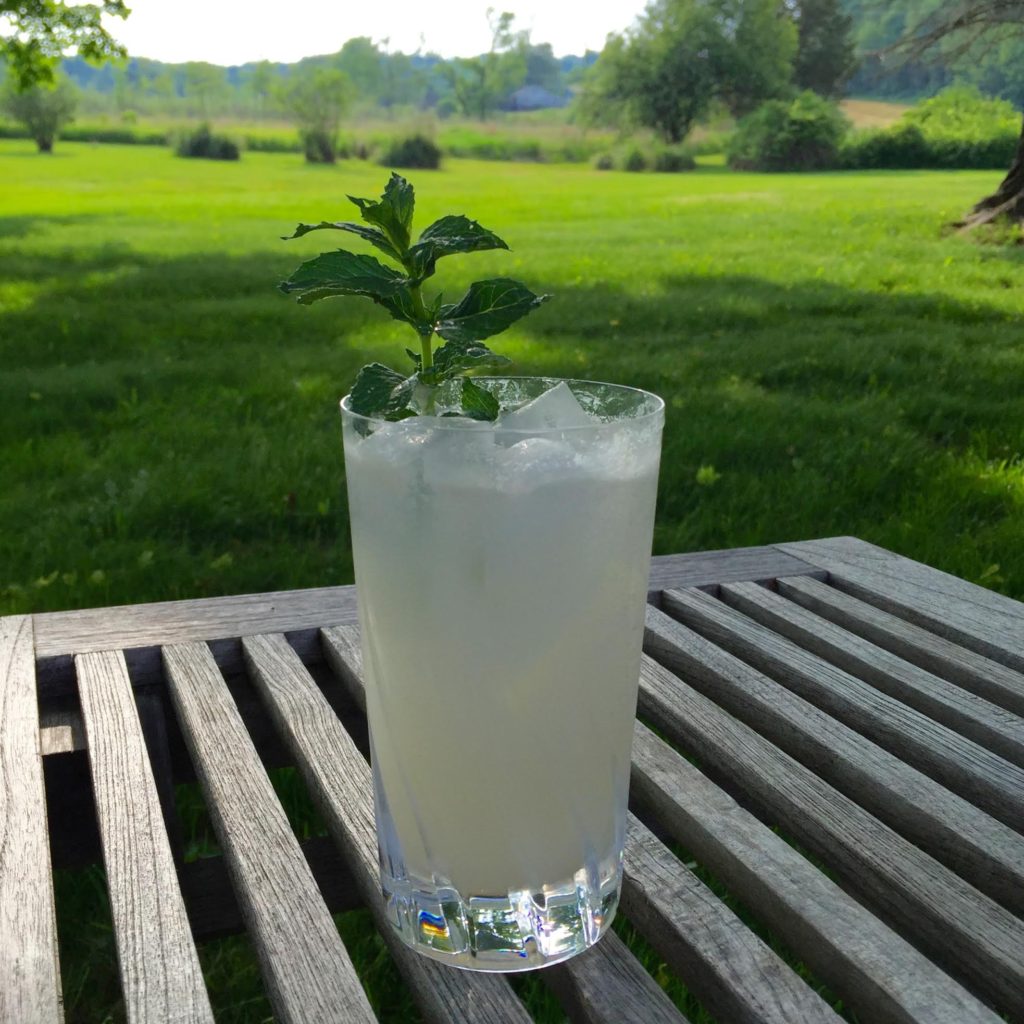 Frosty cocktail on a teak table outdoors.