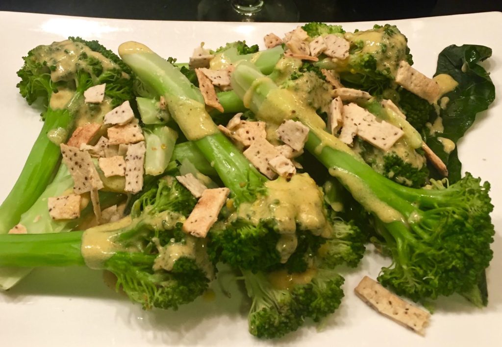 Carrie Mae's Kitchen Chia Seeds Crunchy Strips topping a finished broccoli dish on a white platter.