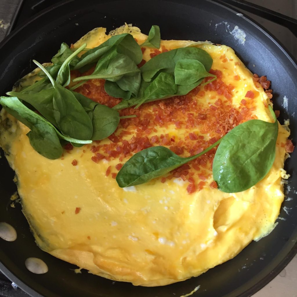 Chef’s Cut Honey Barbeque Chicken Jerky & Spinach Omelet in a pan.