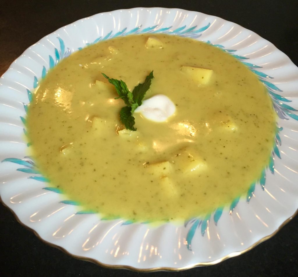 Chilled Curried Zucchini soup with apples, mint and yogurt garnish in a Limoges bowl.