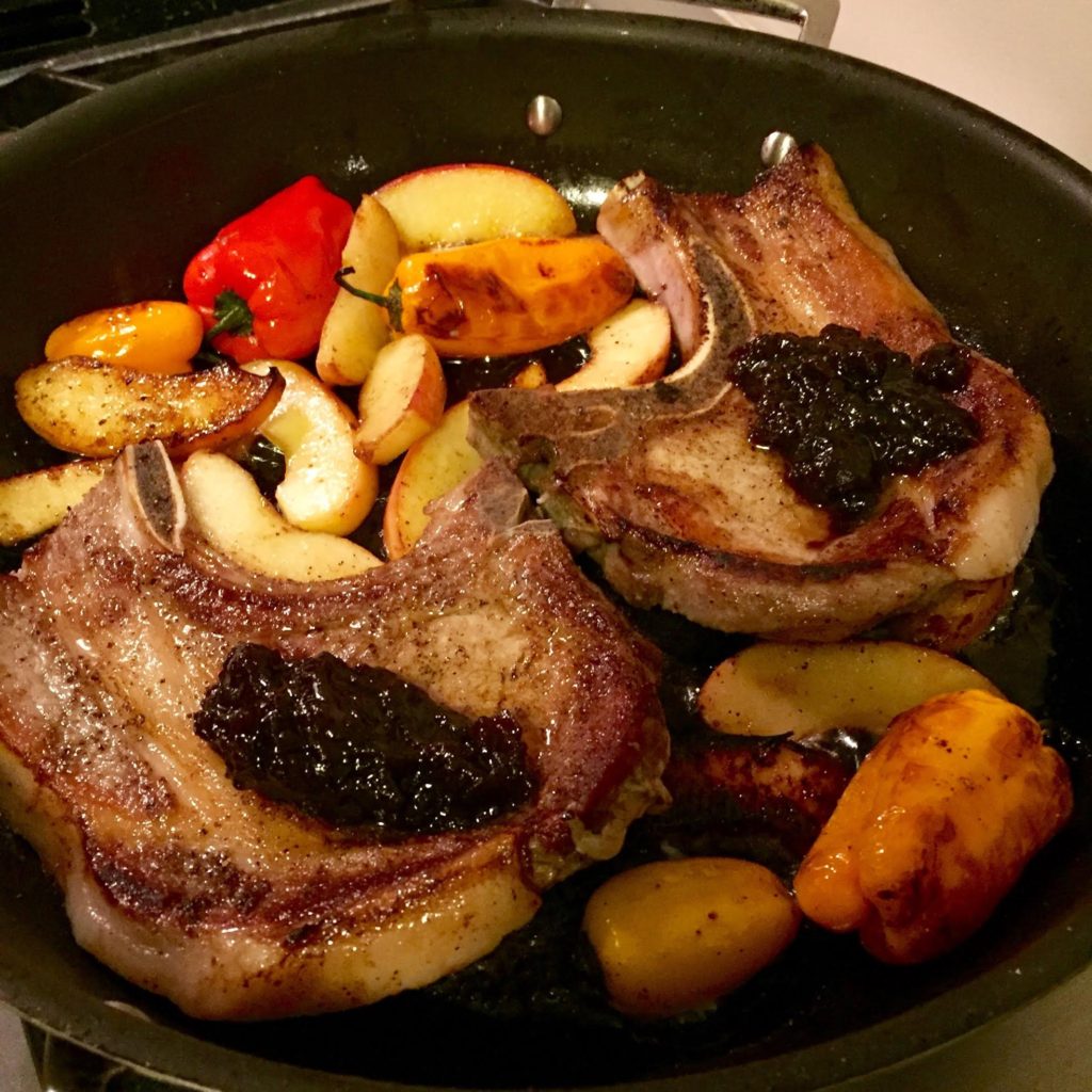 English Provender Caramelized Red Onion Chutney on pork chops in a skillet.