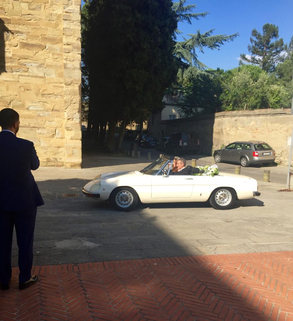 White convertible Alfa Romeo car with a bride and her father.