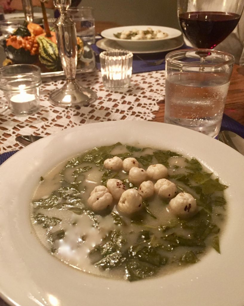 Mom's Popped Lotus Seeds garnishing a tangy sorrel & potato with bacon soup in a white flat soup bowl.