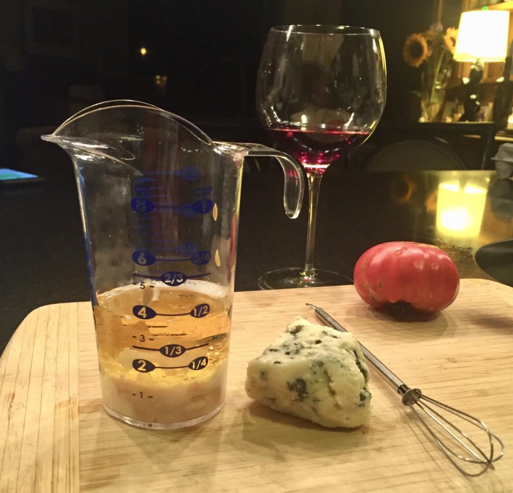 POURfect measuring beaker with Roquefort cheese, a tomato and a glass of wine.