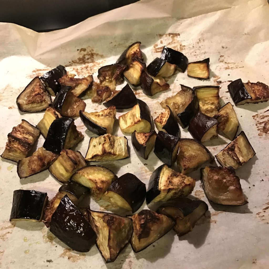 Oven raosted eggplant on white parchment paper just out of the oven.