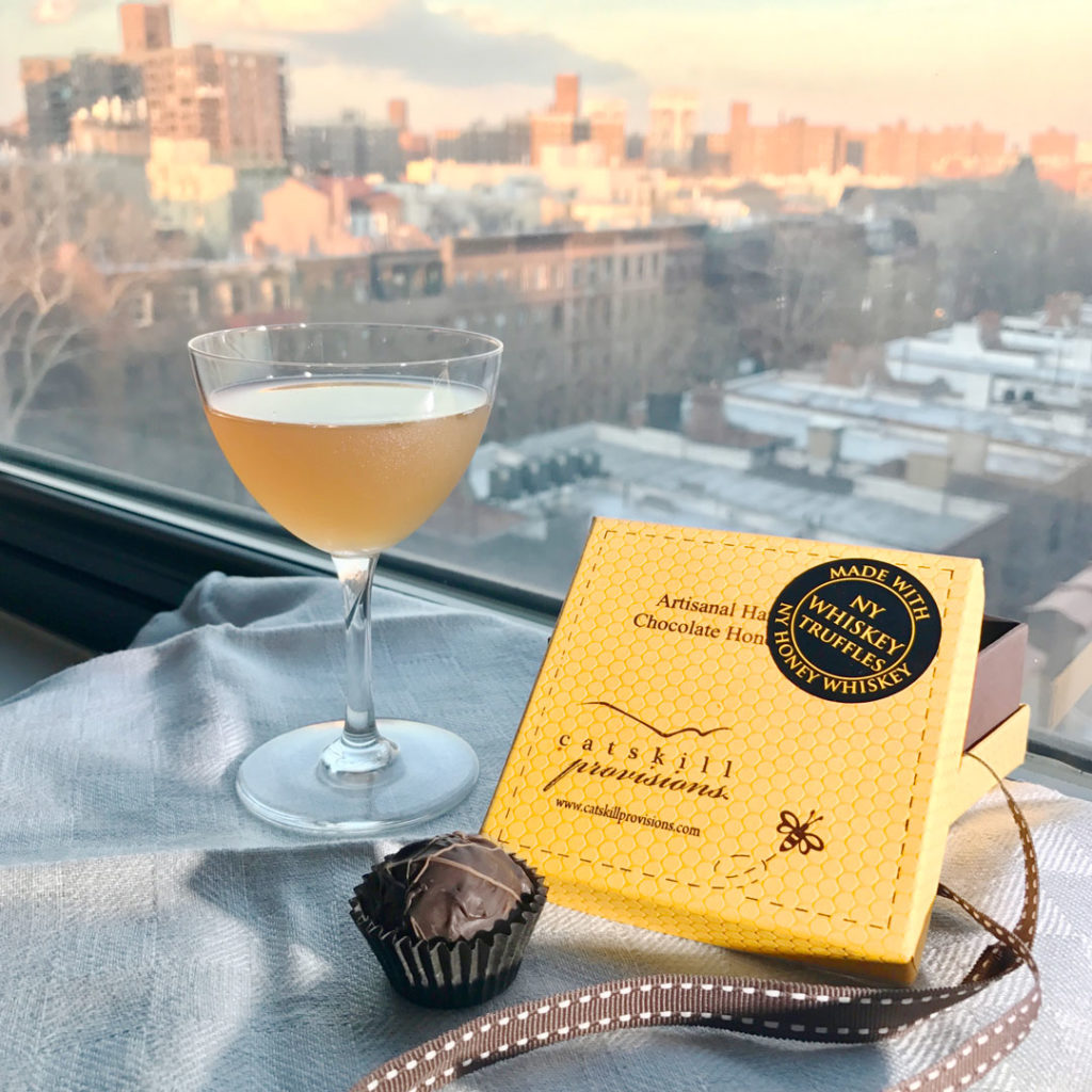 Catskill Provisions NY Honey Whiskey Truffles with cocktail and window in the background.
