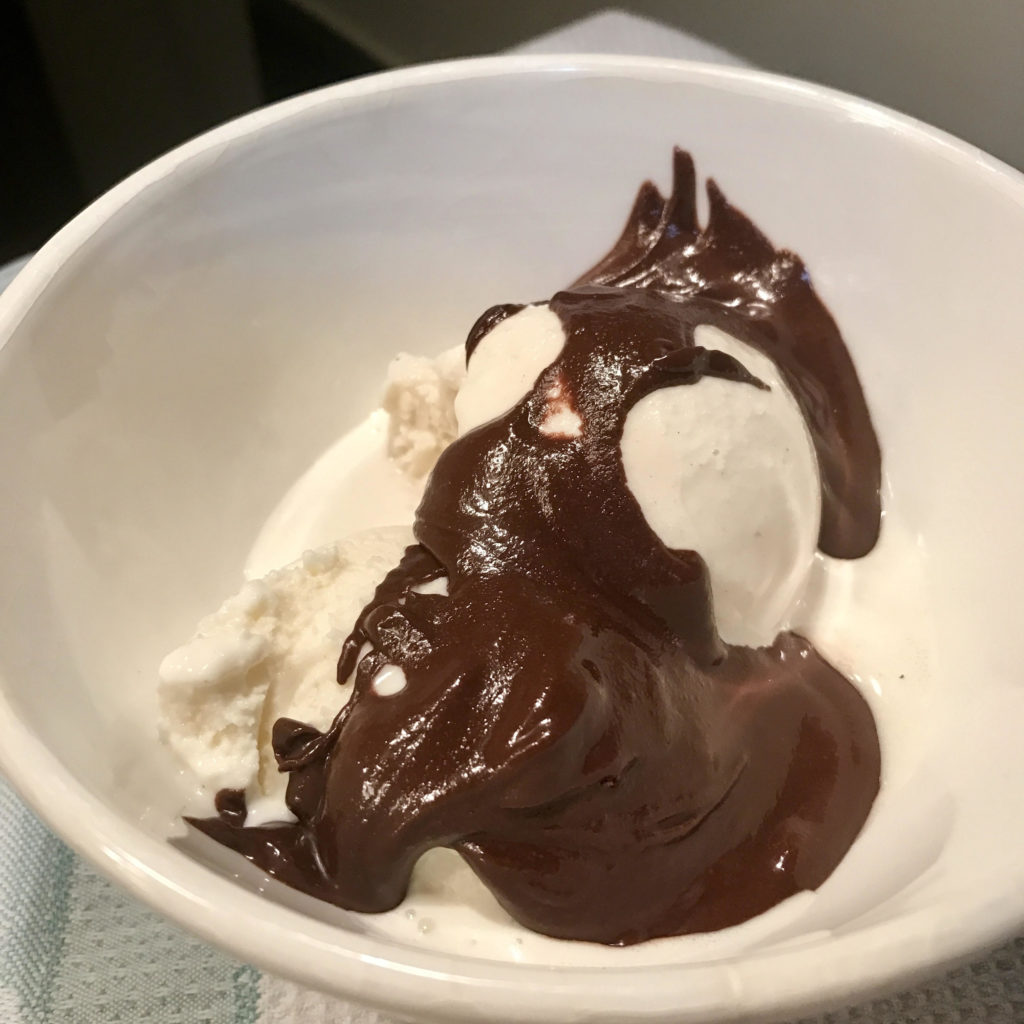 Soom chocolate tahini on ice cream in a white bowl.