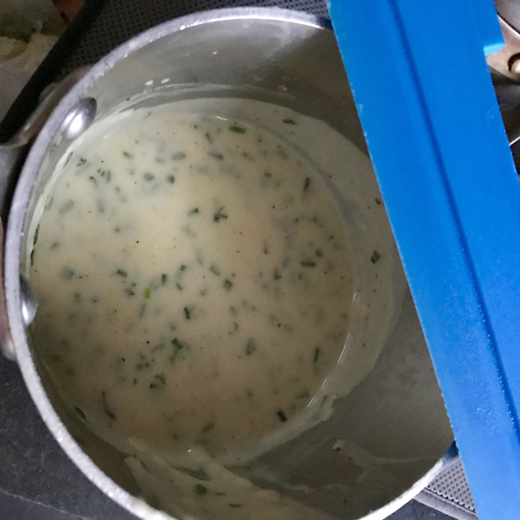 Salmon casserole white sauce in a small All-Clad pot.
